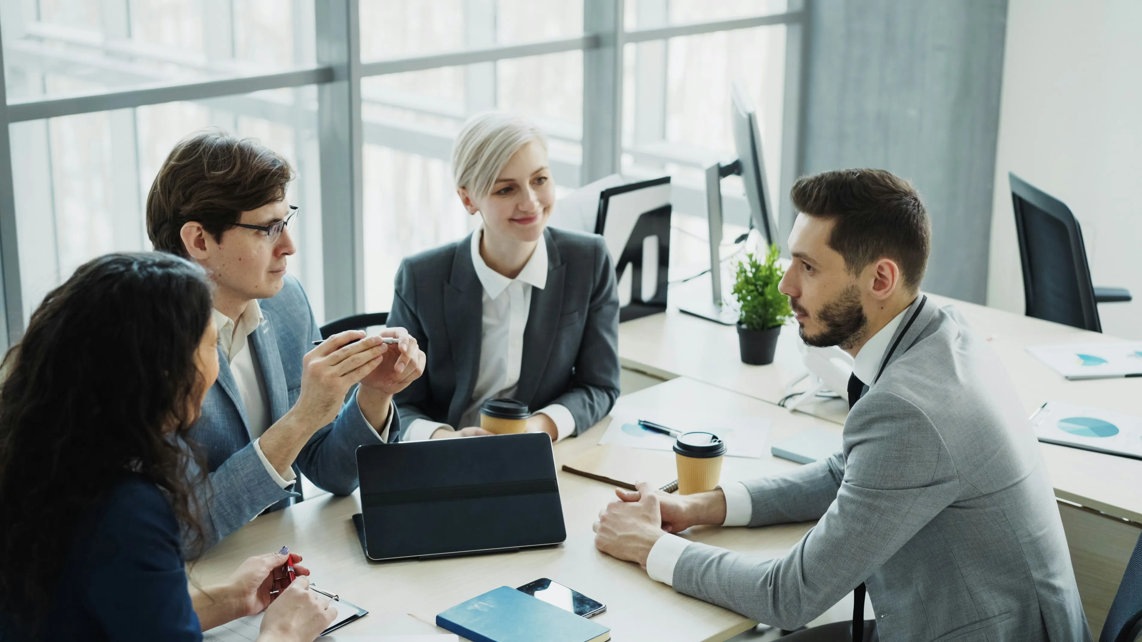 Business professionals reviewing financial performance charts during a healthcare facility sale discussion